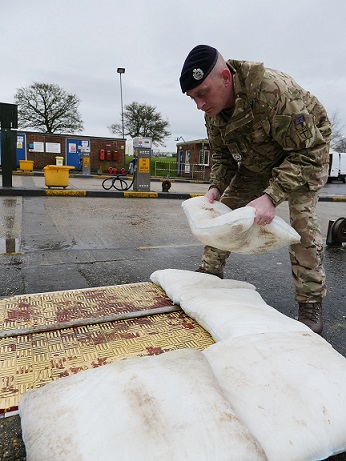 A soldier from the British Army  building a wall of FloodSax alternative sandbags